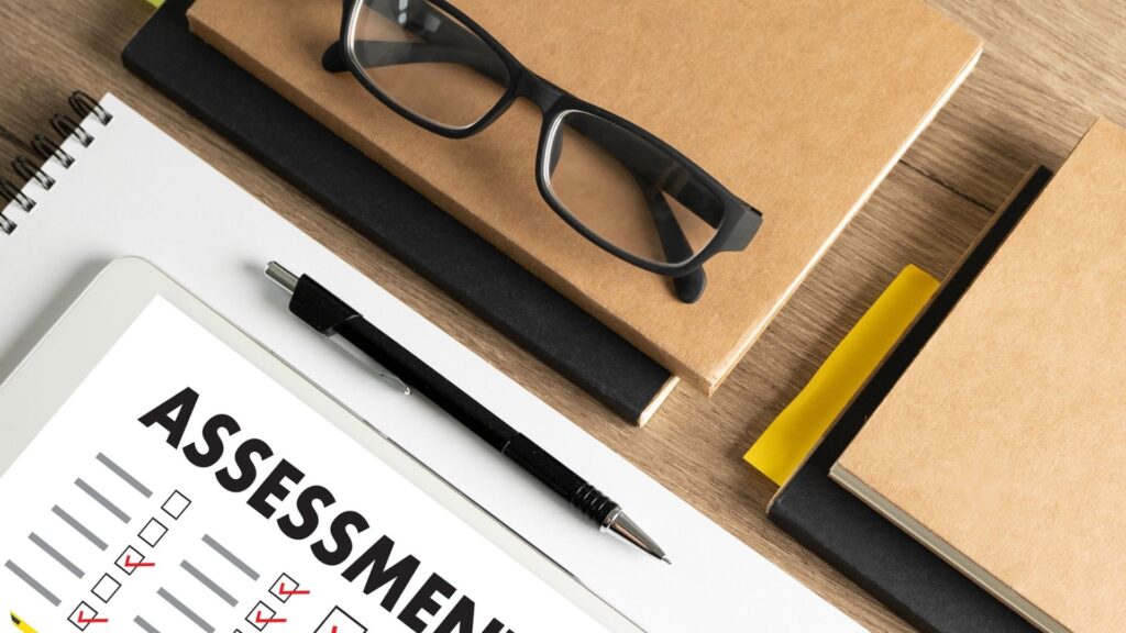 assessment form, spectacles and notebooks