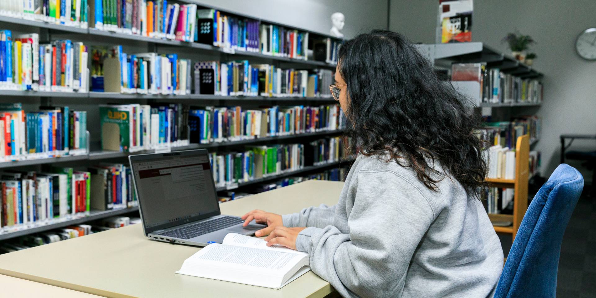 Student in Library tying on a laptop